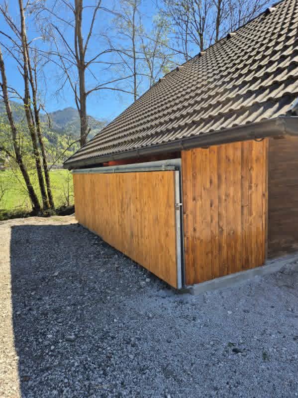 Dokončana drsna vrata s kovinsko konstrukcijo in leseno oblogo, ki jo je dodal naročnik